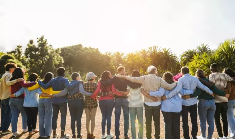 Group of multigenerational people hugging each others - Support, multiracial and diversity concept - Main focus on senior man with white hairs