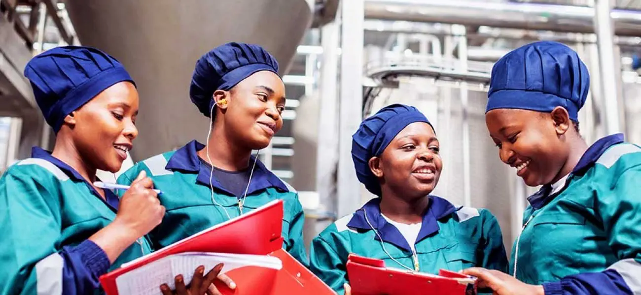 Africa, Dairy Factory, Workers - Dairy plant workers having casual discussion before their shift begins