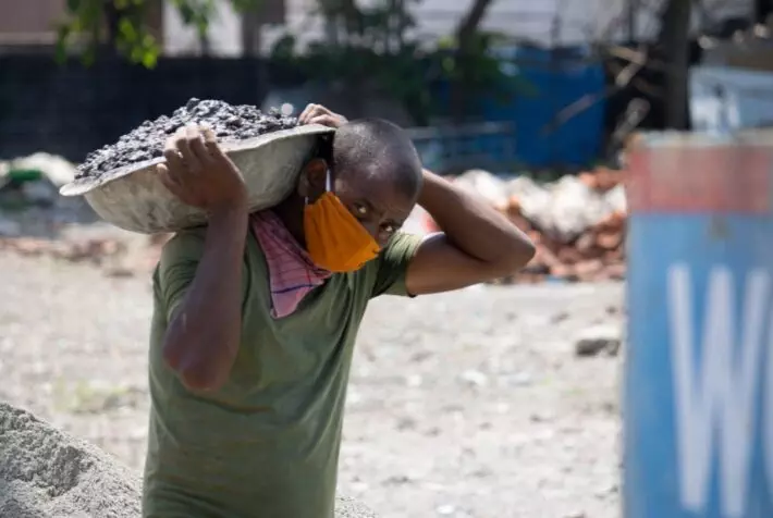 Men doing labor work wearing face mask.