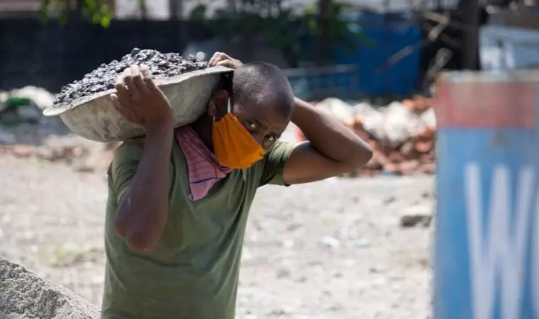 Men doing labor work wearing face mask.